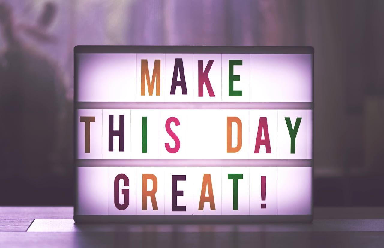 Cartel retroiluminado con la frase "Make this day great!" con intención de motivar